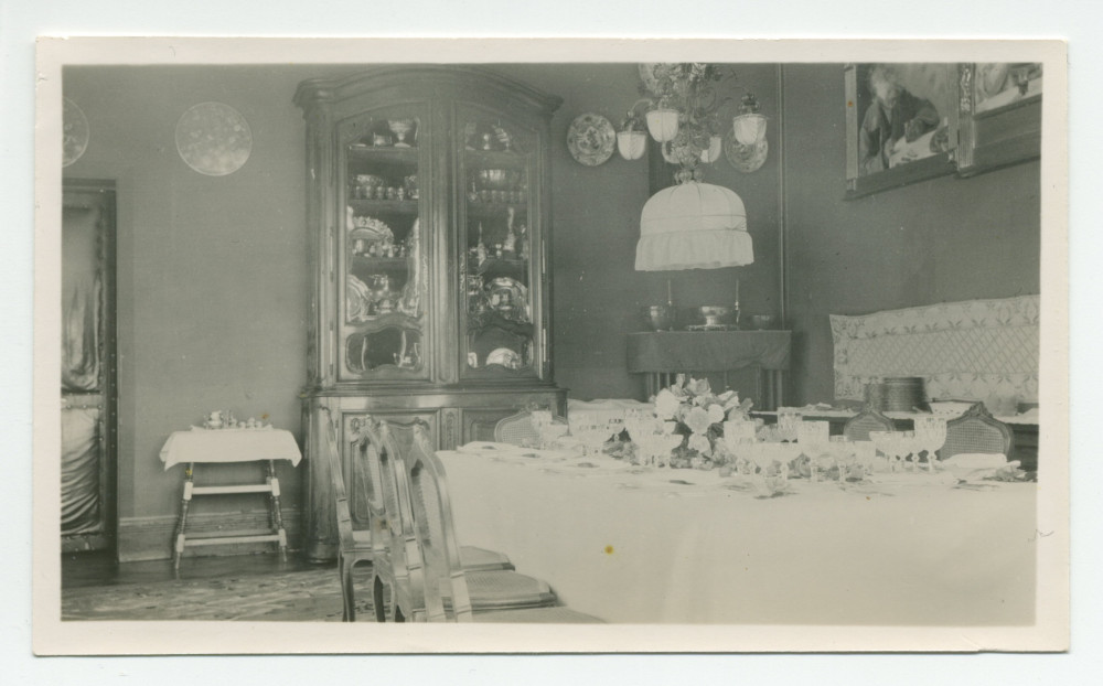 Photographie de la salle à manger de Riond-Bosson, avec la table dressée et le vaisselier à argenterie – extraite d'un album de la famille Obuchowicz