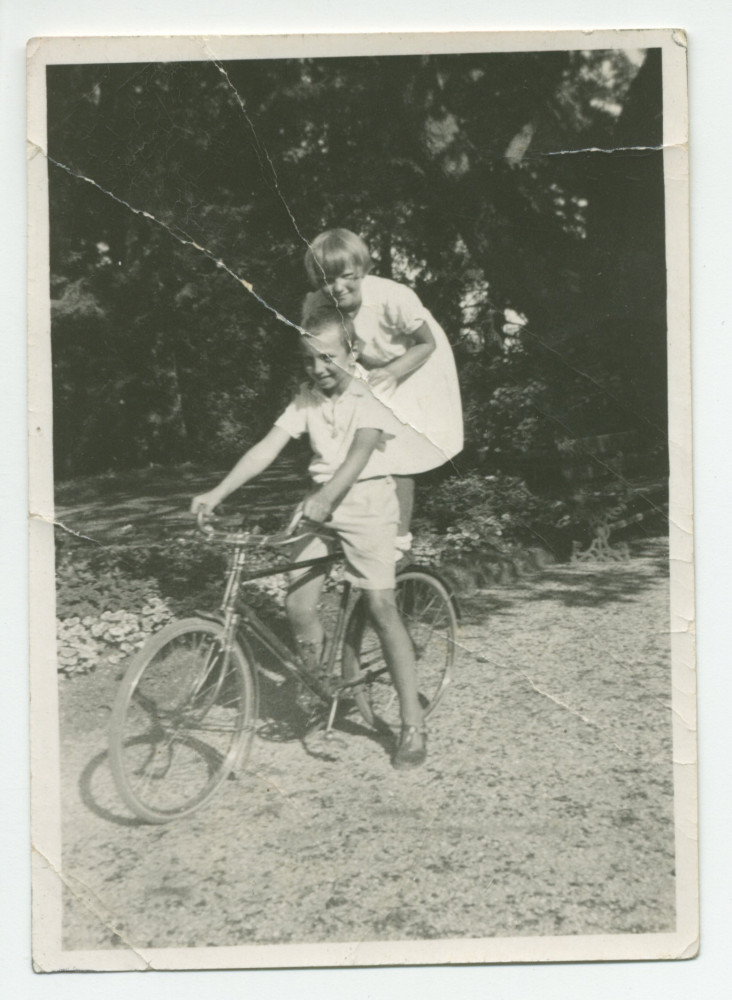 Photographie d'Ignace Obuchowicz (filleul de Paderewski) faisant du vélo dans le parc de Riond-Bosson, avec Anne Strakacz (fille de Sylwin, secrétaire de Paderewski) sur son dos, en 1932