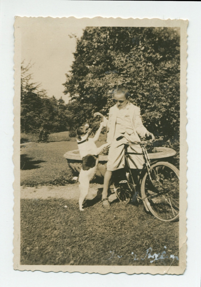 Photographie d'Ignace Obuchowicz (filleul de Paderewski) faisant du vélo dans le parc de Riond-Bosson en compagnie d'un chien dressé sur ses pattes arrières, en 1934 – extraite d'un album de la famille Obuchowicz