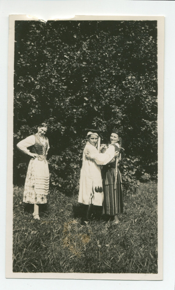 Photographie d'Ignace Obuchowicz (filleul de Paderewski) en costume traditionnel polonais dans le parc de Riond-Bosson, debout en compagnie d'Anne Strakacz (fille de Sylwin, secrétaire de Paderewski) et d'Anelka Lubussa (?), en 1936