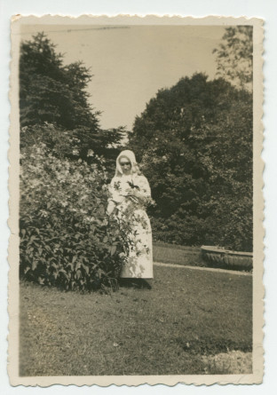 Photographie d'une infirmière (?) cueillant des fleurs pour Hélène Paderewska, malade, dans le parc de Riond-Bosson – extraite d'un album de la famille Obuchowicz