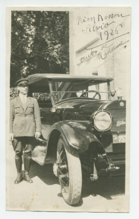 Photographie de Silvio Mongini, le chauffeur, en livrée, à côté de la Cadillac d'Hélène Paderewska, devant la villa de Riond-Bosson, en 1926