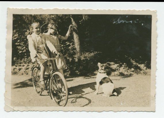 Photographie d'Ignace Obuchowicz (filleul de Paderewski) faisant du vélo avec Anne Strakacz (fille de Sylwin, secrétaire de Paderewski) et un chien dans le parc de Riond-Bosson, en 1934 – extraite d'un album de la famille Obuchowicz