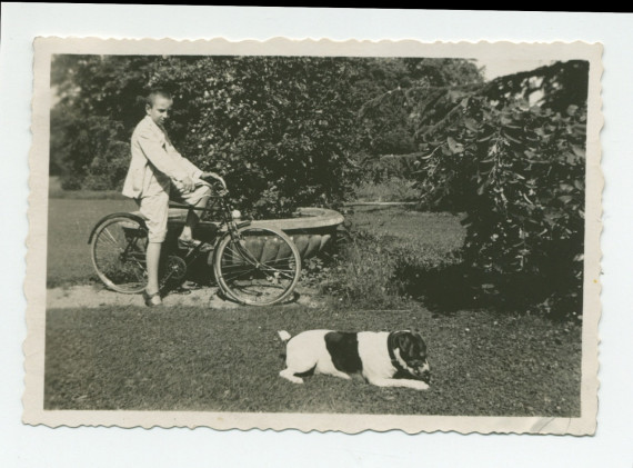 Photographie d'Ignace Obuchowicz (filleul de Paderewski) faisant du vélo dans le parc de Riond-Bosson en compagnie d'un chien, en 1934 – extraite d'un album de la famille Obuchowicz