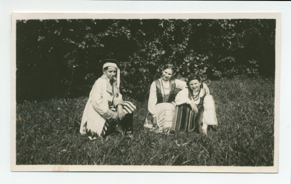 Photographie d'Ignace Obuchowicz (filleul de Paderewski) en costume traditionnel polonais dans le parc de Riond-Bosson, assis en compagnie d'Anne Strakacz (fille de Sylwin, secrétaire de Paderewski) et de Loulou (Lulusia) Dolézal (fille du jardinier), en 1