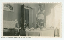 Photographie de la salle à manger de Riond-Bosson, avec la table dressée et la porte ouverte sur le salon (et les photographies dédicacées) – extraite d'un album de la famille Obuchowicz