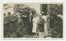 Photographie d'un groupe de personnes sortant de la villa de Riond-Bosson par l'entrée principale, composé entre autres du compositeur Henryk Opienski et d'Henry Vallotton (conseiller national et agent d'affaires de Paderewski, fumant le cigare)